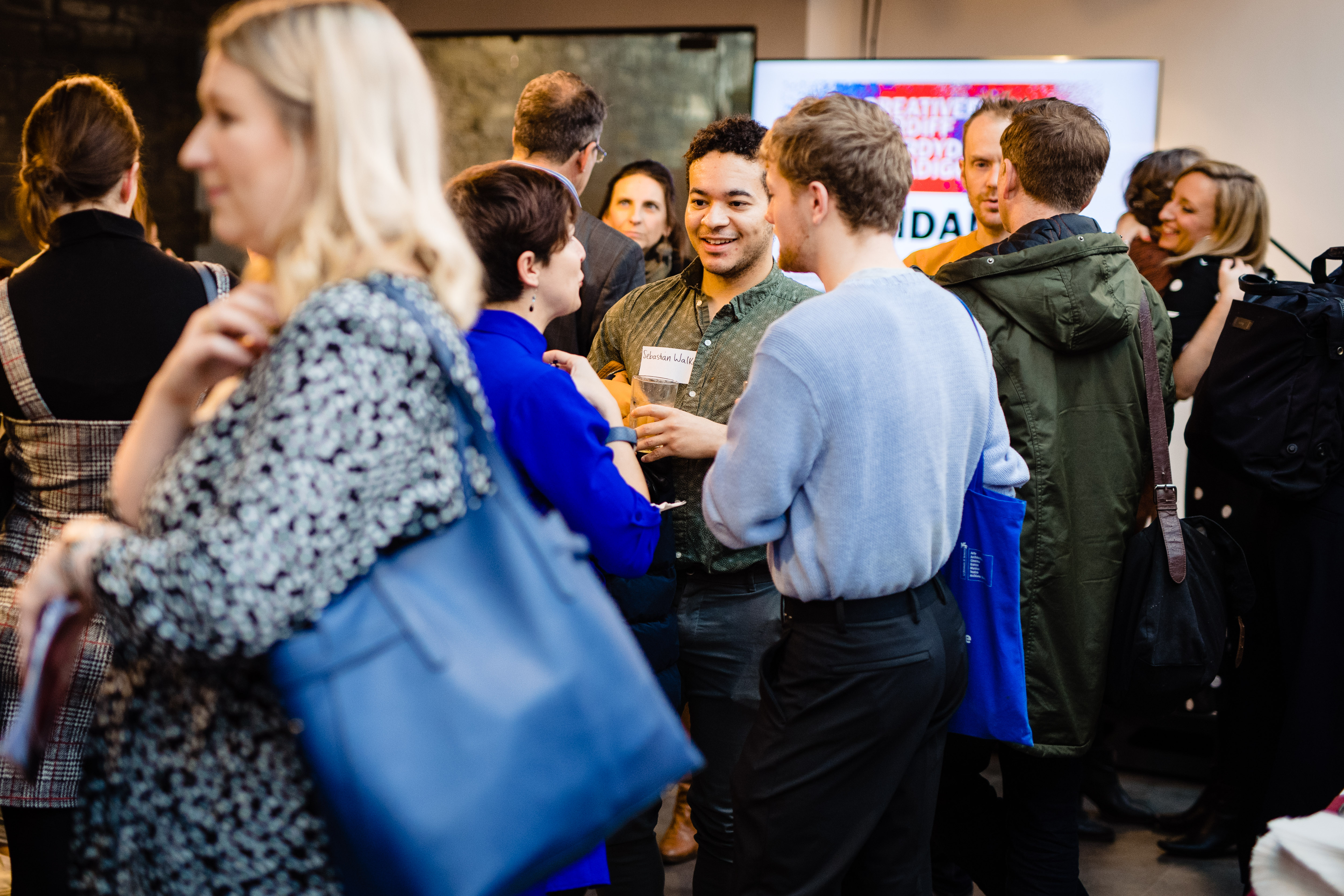 A room filled with people chatting at an event