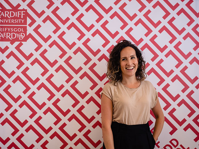 Image of Jane Cook in front of Creative Cardiff logo