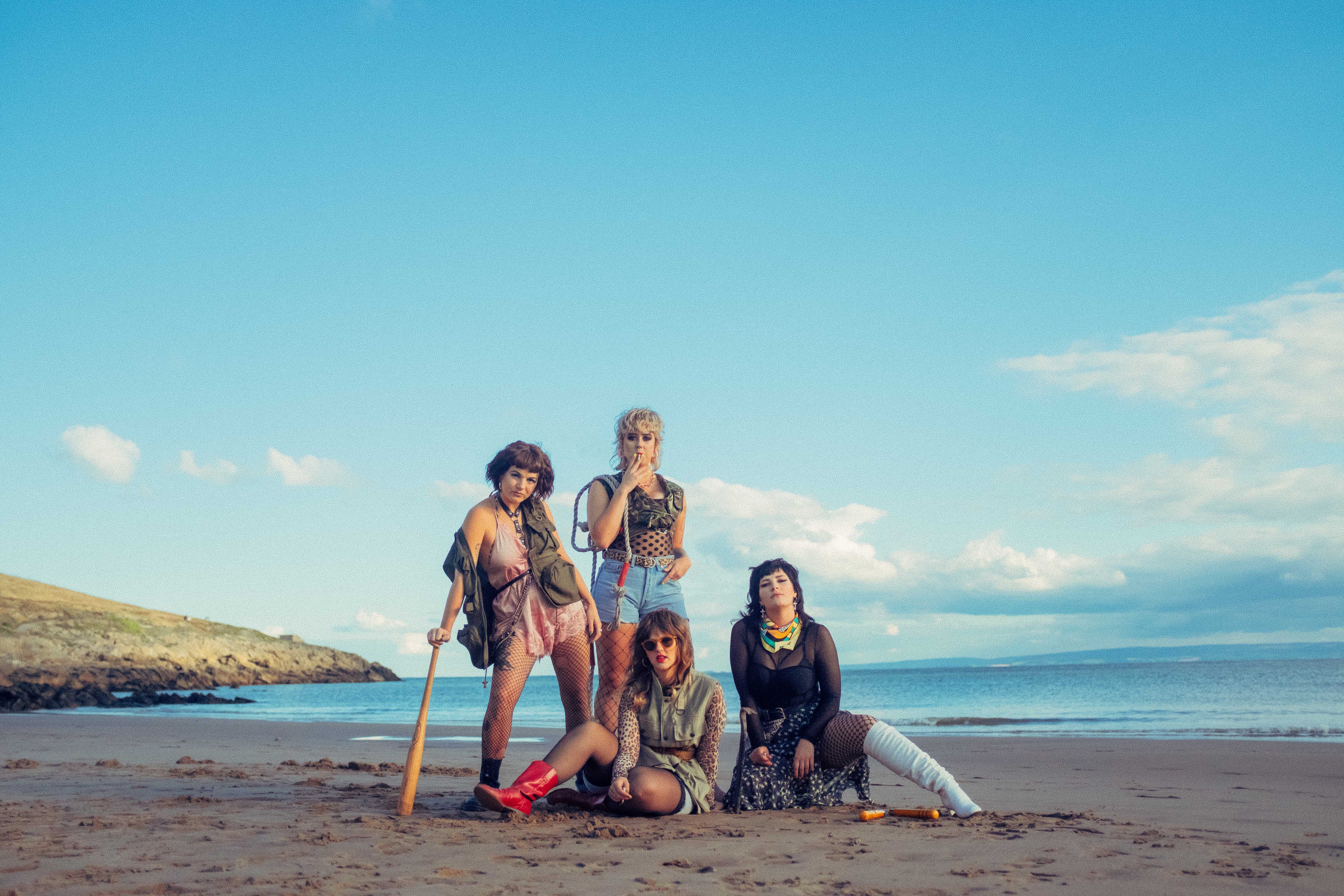 Four members of Panic Shack band on the beach