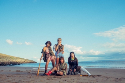 Four members of Panic Shack band sat on a beach